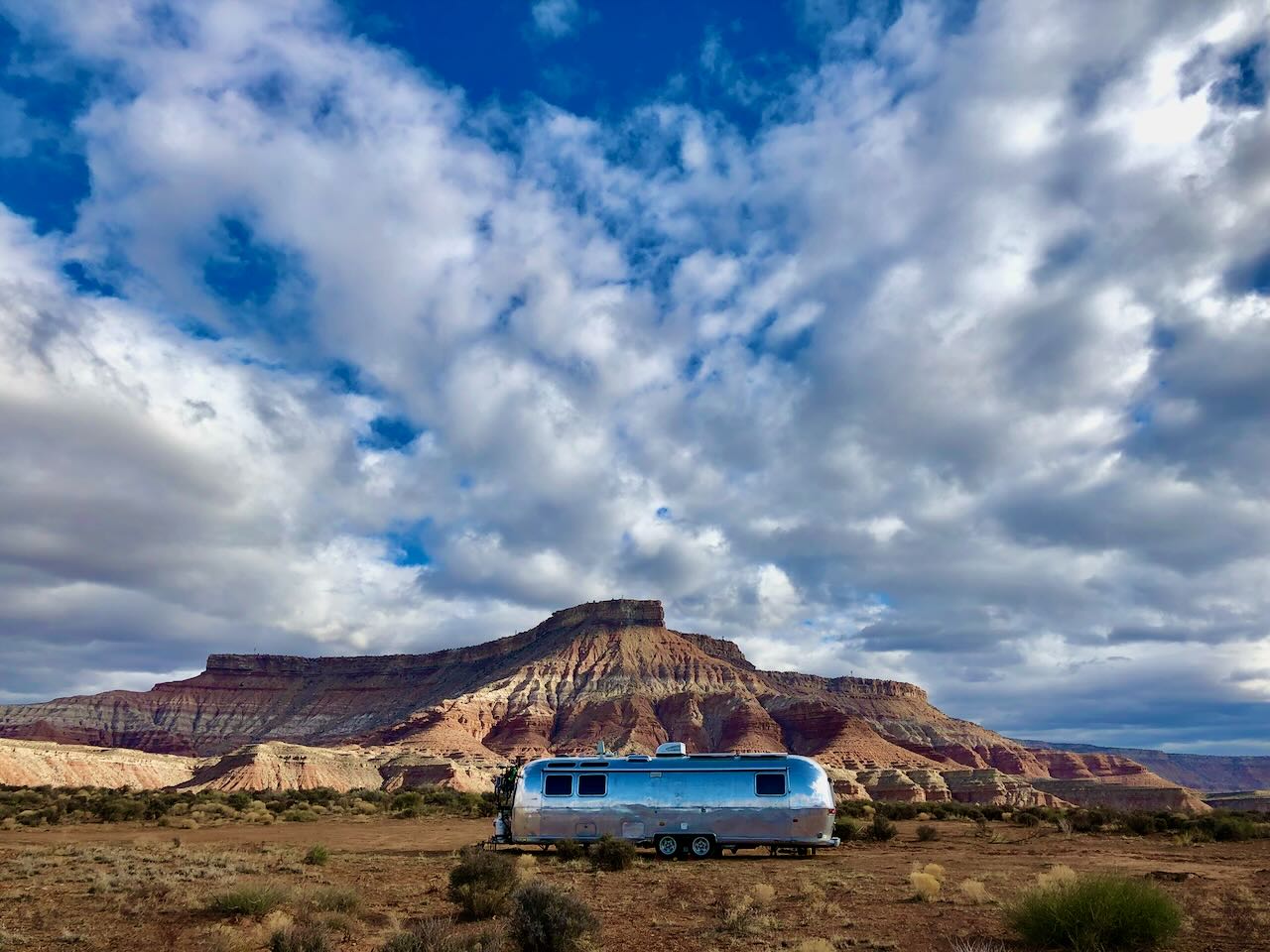Parked beneath a desert butte under a huge sky